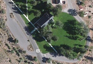 Aerial view of the church with the parking area, green grass and elk.